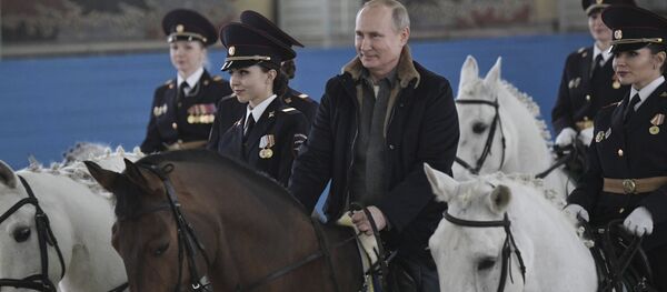 Putin rides a horse during a visit to a mounted police unit to congratulate female officers with International Women's Day. - Sputnik International