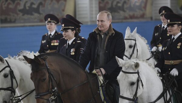 Putin rides a horse during a visit to a mounted police unit to congratulate female officers with International Women's Day. - Sputnik International