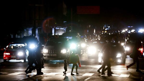 Residents cross a street in the dark after a power outage in Caracas, Venezuela, Thursday, March 7, 2019. A power outage left much of Venezuela in the dark early Thursday evening in what appeared to be one of the largest blackouts yet in a country where power failures have become increasingly common. Crowds of commuters in capital city Caracas were walking home after metro service ground to a halt and traffic snarled as cars struggled to navigate intersections where stoplights were out. - Sputnik International