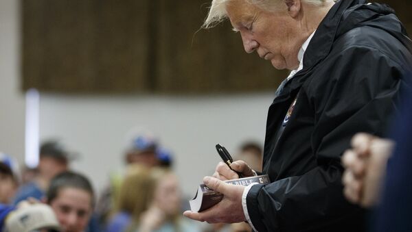 President Donald Trump signs a Bible as he greets people at Providence Baptist Church in Smiths Station, Alabama - Sputnik International