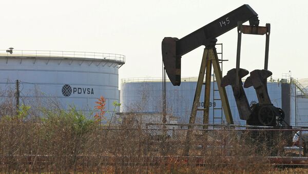 An oil pumpjack and a tank with the corporate logo of state oil company PDVSA are seen in an oil facility in Lagunillas - Sputnik International