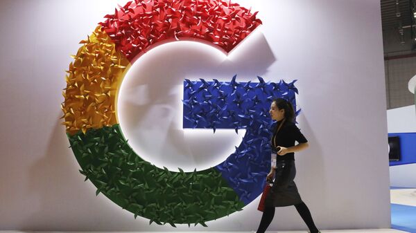 In this Monday, Nov. 5, 2018, photo, a woman carries a fire extinguisher past the logo for Google at the China International Import Expo in Shanghai - Sputnik International