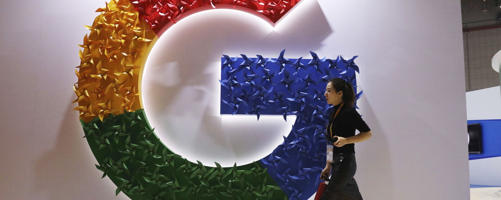 In this 5 November 2018, photo, a woman carries a fire extinguisher past the logo for Google at the China International Import Expo in Shanghai - Sputnik International, 1920, 24.06.2021