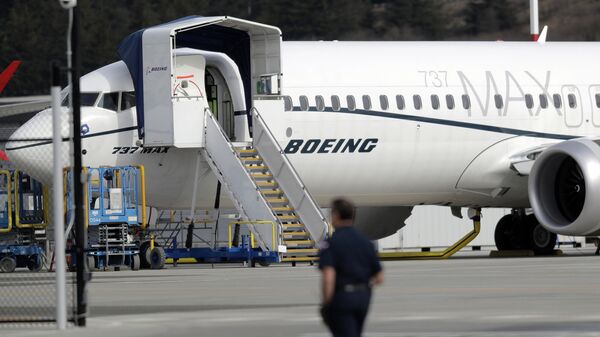 A worker walks next to a Boeing 737 MAX 8 airplane parked at Boeing Field, Thursday, March 14, 2019, in Seattle - Sputnik International
