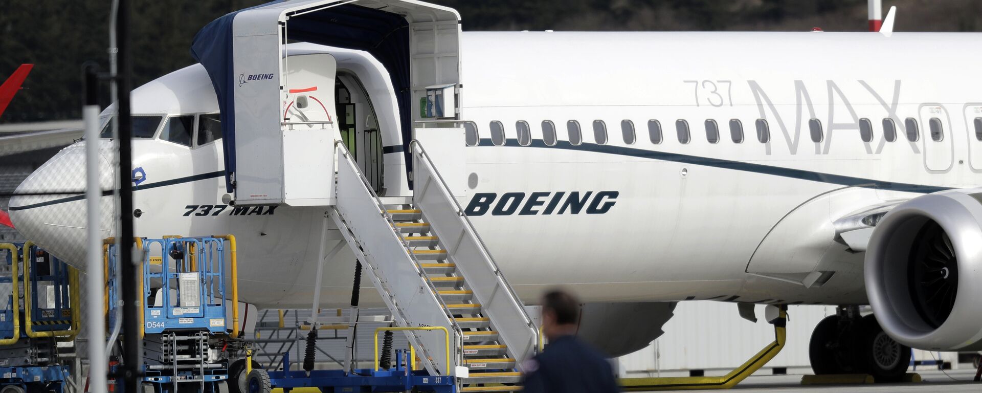 A worker walks next to a Boeing 737 MAX 8 airplane parked at Boeing Field, Thursday, March 14, 2019, in Seattle - Sputnik International, 1920, 04.11.2021