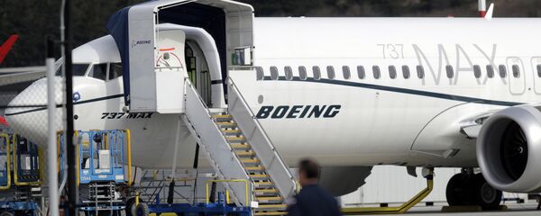 A worker walks next to a Boeing 737 MAX 8 airplane parked at Boeing Field, Thursday, March 14, 2019, in Seattle A worker walks next to a Boeing 737 MAX 8 airplane parked at Boeing Field, Thursday, March 14, 2019, in Seattle - Sputnik International