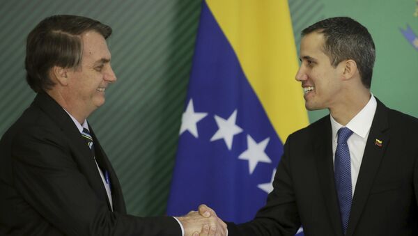 Brazil's President Jair Bolsonaro, left, and Venezuela's self-proclaimed interim president Juan Guaido shake hands, Brasilia, Brazil, Thursday, Feb.28 - Sputnik International