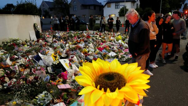 People visit a memorial site for victims of Friday's shooting, in front of the Masjid Al Noor mosque in Christchurch - Sputnik International