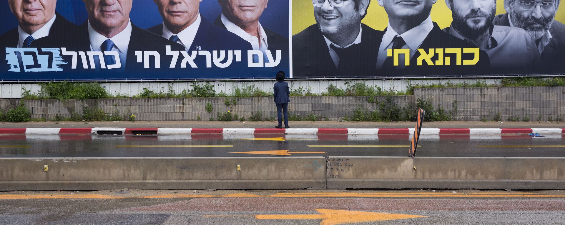 An Ultra-Orthodox Jewish man looks at an elections billboards of the Blue and White party leaders, from left to right, Moshe Yaalon, Benny Gantz, Yair Lapid and Gabi Ashkenazi, alongside a panel on the right showing Prime Minister Benjamin Netanyahu flanked by extreme right politicians, from the left, Itamar Ben Gvir, Bezalel Smotrich and Michael Ben Ari in Bnei Brak, Israel, Saturday, March 16, 2019. Hebrew reads on the left billboard The nation of Israel lives and on the right billboard Kahana Lives in a reference to a banned ultranationalist party in the 1994. - Sputnik International, 1920, 08.01.2021