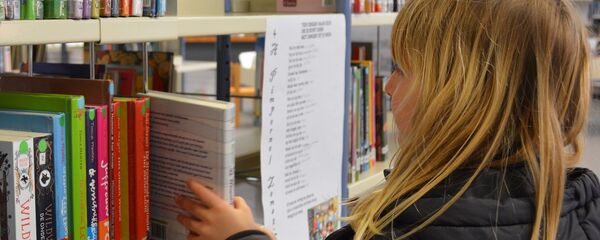 A young girl picking up a book A young girl picking up a book - Sputnik International