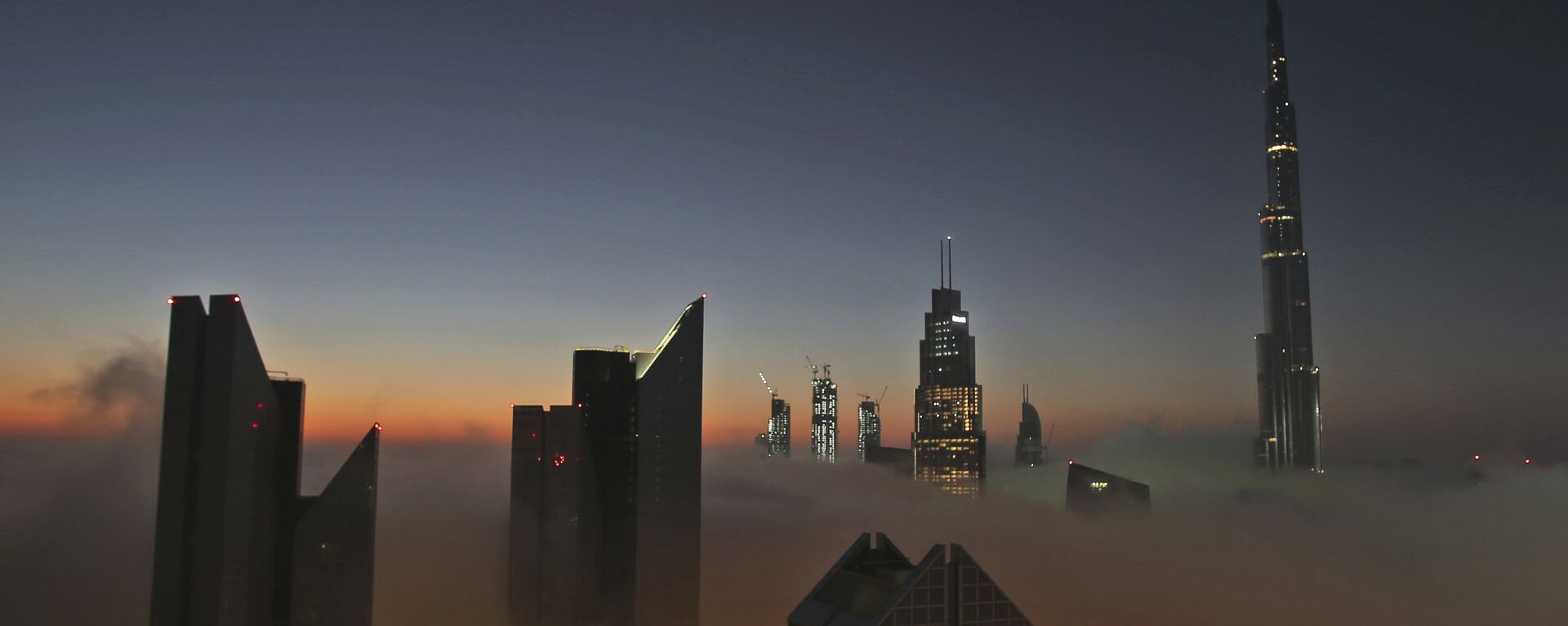 The sun rises over the city skyline with the Burj Khalifa, world's tallest building at the backdrop, seen from a balcony on the 42nd floor of a hotel on a foggy day in Dubai, United Arab Emirates, Saturday, Dec. 31, 2016 - Sputnik International, 1920, 05.08.2019