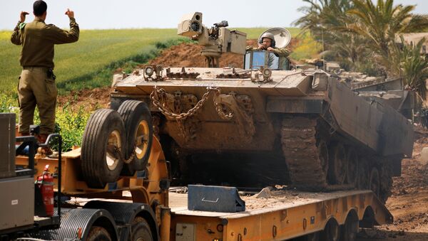 An Israeli soldier directs an armoured personnel carrier (APC) near the border between Israel and Gaza on its Israeli side, March 15, 2019 - Sputnik International