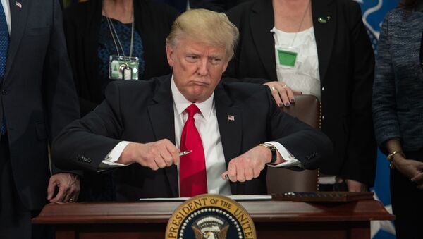 US President Donald Trump takes the cap off a pen to sign an executive order to start the Mexico border wall project at the Department of Homeland Security facility in Washington, DC, on January 25, 2017. - Sputnik International