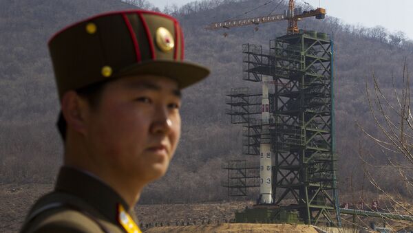 A North Korean soldier stands in front of the country's Unha-3 rocket, slated for liftoff between April 12-16, at a launching site in Tongchang-ri, North Korea on Sunday April 8, 2012. - Sputnik International