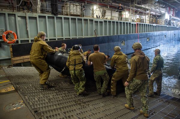 Sailors assigned to Explosive Ordnance Disposal Mobile Unit 2 prepare to launch a combat rubber raiding craft from the well deck of the Royal Fleet Auxiliary landing ship dock Mounts Bay during a mine countermeasures (MCM) task group experiment. Sailors assigned to Explosive Ordnance Disposal Mobile Unit 2 prepare to launch a combat rubber raiding craft from the well deck of the Royal Fleet Auxiliary landing ship dock Mounts Bay during a mine countermeasures (MCM) task group experiment. - Sputnik International