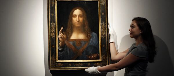 In this Oct. 24, 2017 file photo, an employee poses with Leonardo da Vinci's Salvator Mundi on display at Christie's auction rooms in London. - Sputnik International