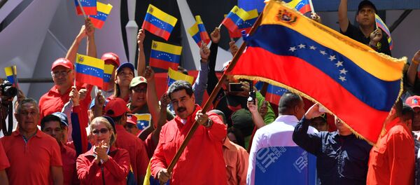 Venezuelan President Nicolas Maduro (C) waves the national flag during a pro-government march in Caracas, on February 23, 2019. - Sputnik International