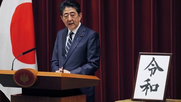 Japanese Prime Minister Shinzo Abe stands beside the Japanese characters of kanji which make up Reiwa, the new imperial era - Sputnik International