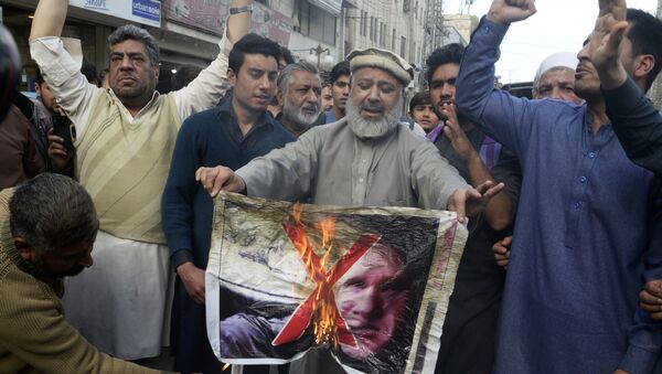 Pakistan traders burn a poster with the image of Brenton Tarrant, the man charged in relation against the March 15 attack on two mosques in Christchurch, during a protest in Peshawar on March 16, 2019 - Sputnik International