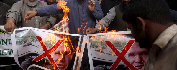 Pakistani traders burn pictures of Brenton Harrison Tarrant, one of the suspects in Christchurch mosques shooting during a demonstration to condemn mosque attack, in Peshawar, Pakistan, Saturday, March 16, 2019 - Sputnik International