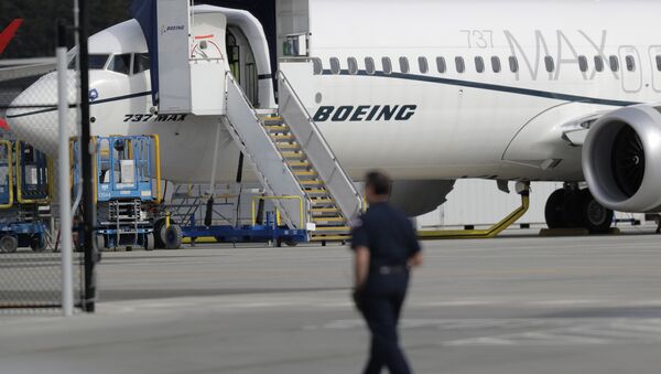 A worker walks next to a Boeing 737 MAX 8 airplane parked at Boeing Field, Thursday, March 14, 2019, in Seattle - Sputnik International