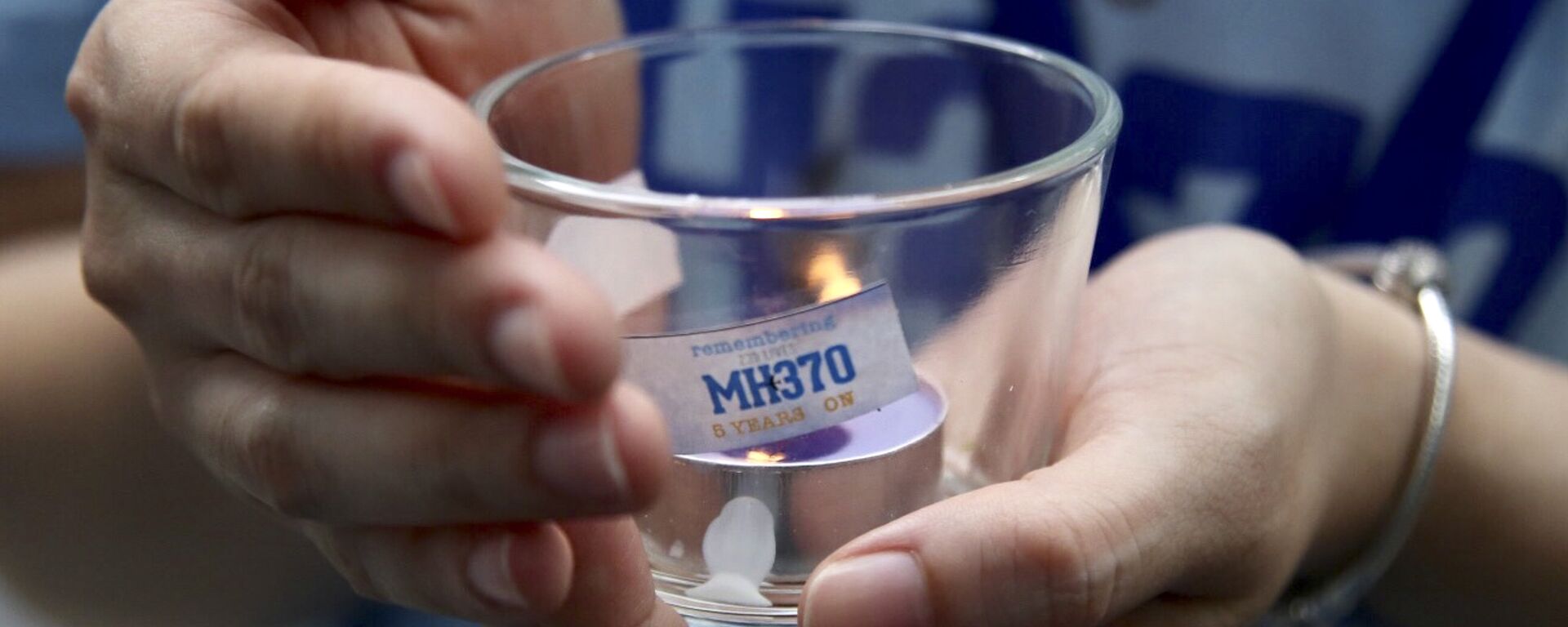 A family member of a passenger of Malaysia Airlines Flight 370, holds a candle during the Day of Remembrance for MH370 event in Kuala Lumpur, Malaysia, Sunday, March 3, 2019 - Sputnik International, 1920, 09.03.2021