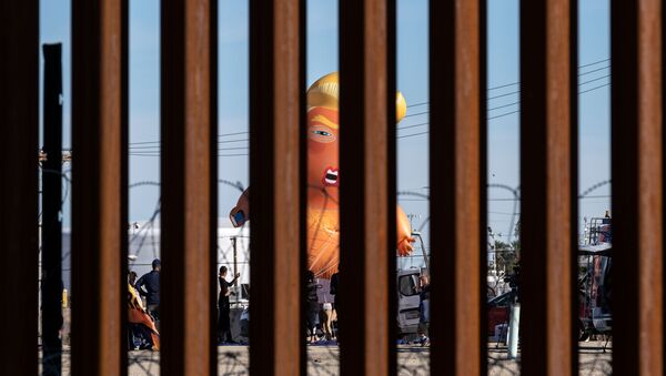 A satirical balloon of a baby US President Donald Trump is seen through the US-Mexico border fence during a demonstration against him prior to his visit to Calexico, California, as seen from Mexicali, Baja California state, Mexico, on April 5, 2019. - Sputnik International