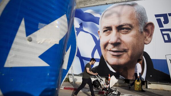 A man walks by an election campaign billboard showing Israel's Prime Minister Benjamin Netanyahu, the Likud party leader, in Tel Aviv, Israel. File photo. - Sputnik International