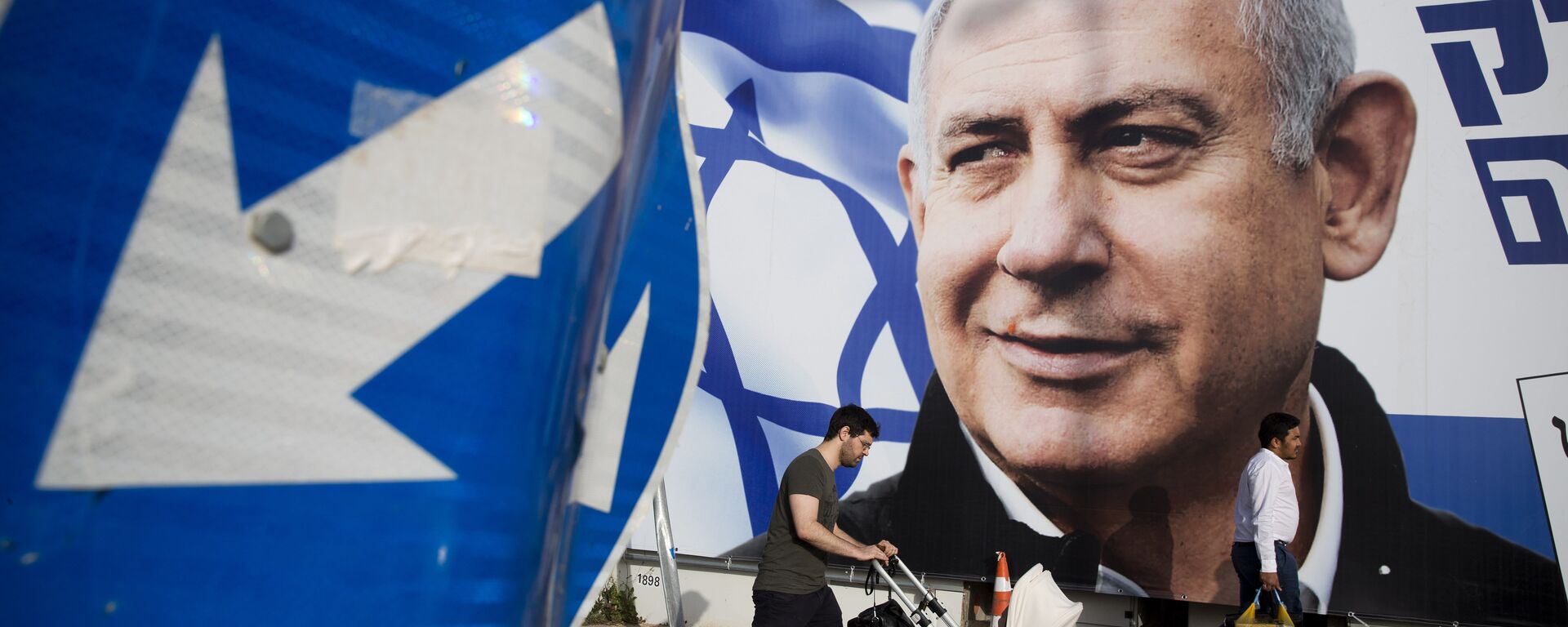 A man walks by an election campaign billboard showing Israel's Prime Minister Benjamin Netanyahu, the Likud party leader, in Tel Aviv, Israel. File photo. - Sputnik International, 1920, 26.06.2022