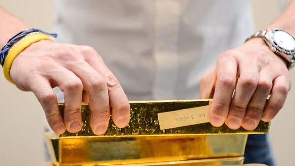 A metal analyst controls the weight of gold bars after the melting of gold, at Italpreziosi gold refinery company, in Arezzo, on 11 May, 2012 - Sputnik International