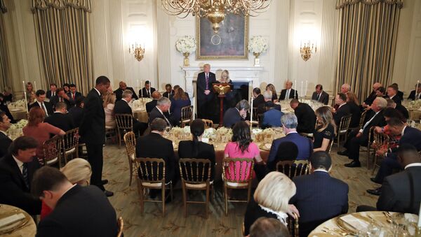 President Donald Trump bows his head as pastor Paula White leads the room in prayer during a dinner for evangelical leaders in the State Dining Room of the White House on 27 August 2018 - Sputnik International