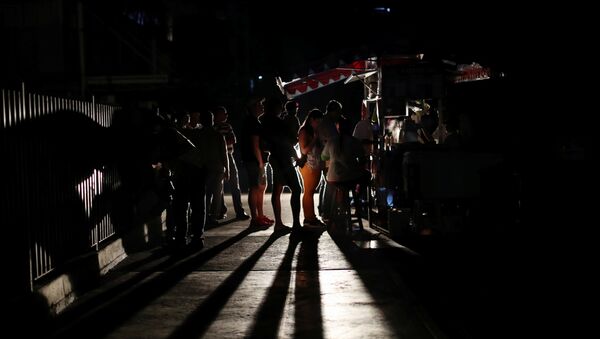 Locals gather at a street food cart during a blackout in Caracas, Venezuela March 29, 2019 - Sputnik International
