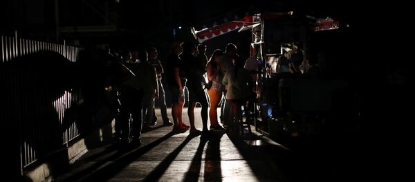 Locals gather at a street food cart during a blackout in Caracas, Venezuela March 29, 2019 - Sputnik International