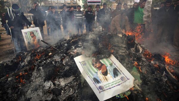 Libyan protesters burn a poster of Libyan leader Moammar Gadhafi as it is burned during a demonstration against him in Benghazi, eastern Libya, Wednesday, March 2 , 2011 - Sputnik International
