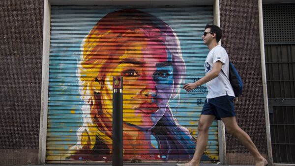 A man walks in front of a graffiti by street artist Axe Colours portraying British actress Emilia Clarke known for playing Daenerys Targaryen in The Game of Thrones TV series in Barcelona on July 30, 2017 - Sputnik International