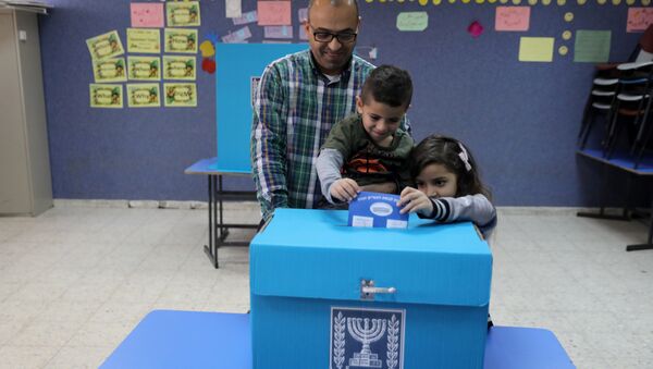 An Israeli-Arab father casts a ballot together with his children, as Israelis vote in a parliamentary election, at a polling station in Umm al-Fahm, Israel - Sputnik International