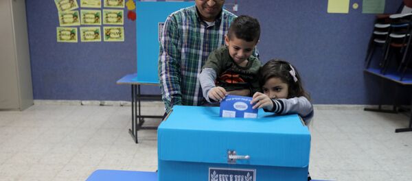 An Israeli-Arab father casts a ballot together with his children, as Israelis vote in a parliamentary election, at a polling station in Umm al-Fahm, Israel - Sputnik International