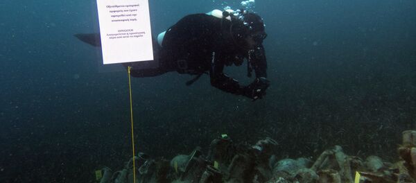 In this photo taken on Sunday, April 7, 2019, an archaeologists dives next ancient amphoras from a 5th Century B.C. shipwreck, the first ancient shipwreck to be opened to the public in Greece, including to recreational divers who will be able to visit the wreck itself, near the coast of Peristera, Greece. - Sputnik International