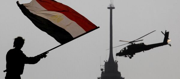 An opponent of Egypt's ousted president Mohammed Morsi waves a national flag as a military helicopter flies over Tahrir Square in Cairo, Egypt, Friday, July 5, 2013 An opponent of Egypt's ousted president Mohammed Morsi waves a national flag as a military helicopter flies over Tahrir Square in Cairo, Egypt, Friday, July 5, 2013 - Sputnik International