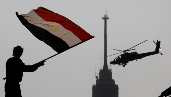 An opponent of Egypt's ousted president Mohammed Morsi waves a national flag as a military helicopter flies over Tahrir Square in Cairo, Egypt, Friday, July 5, 2013 - Sputnik International