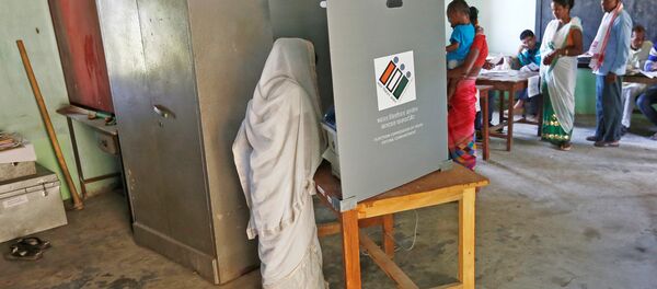 A woman casts her vote as others wait for their turn at a polling station during the first phase of general election in Majuli, a large river island in the Brahmaputra river, in the northeastern Indian state of Assam, India April 11, 2019 - Sputnik International
