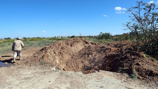 A crater is seen at the blast site after an air strike at Mitiga airport in Tripoli - Sputnik International