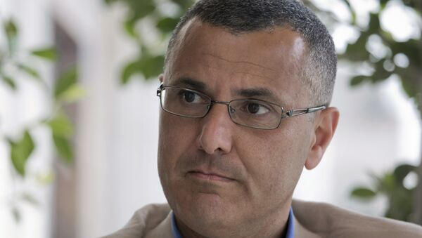 Omar Barghouti listens during an interview with the Associated Press in the West Bank city of Ramallah, Tuesday, May 10, 2016. Barghouti, a Qatari-born Palestinian who is married to an Israeli woman and leader of the international boycott movement against Israel, on Tuesday accused Israeli authorities of imposing a travel ban on him as retribution for his political activities. - Sputnik International