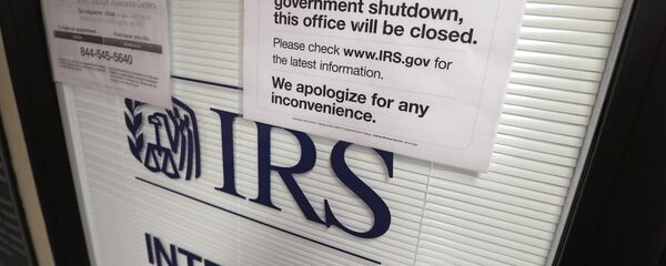 Doors at the Internal Revenue Service (IRS) in the Henry M. Jackson Federal Building are locked and covered with blinds as a sign posted advises that the office will be closed during the partial government shutdown - Sputnik International
