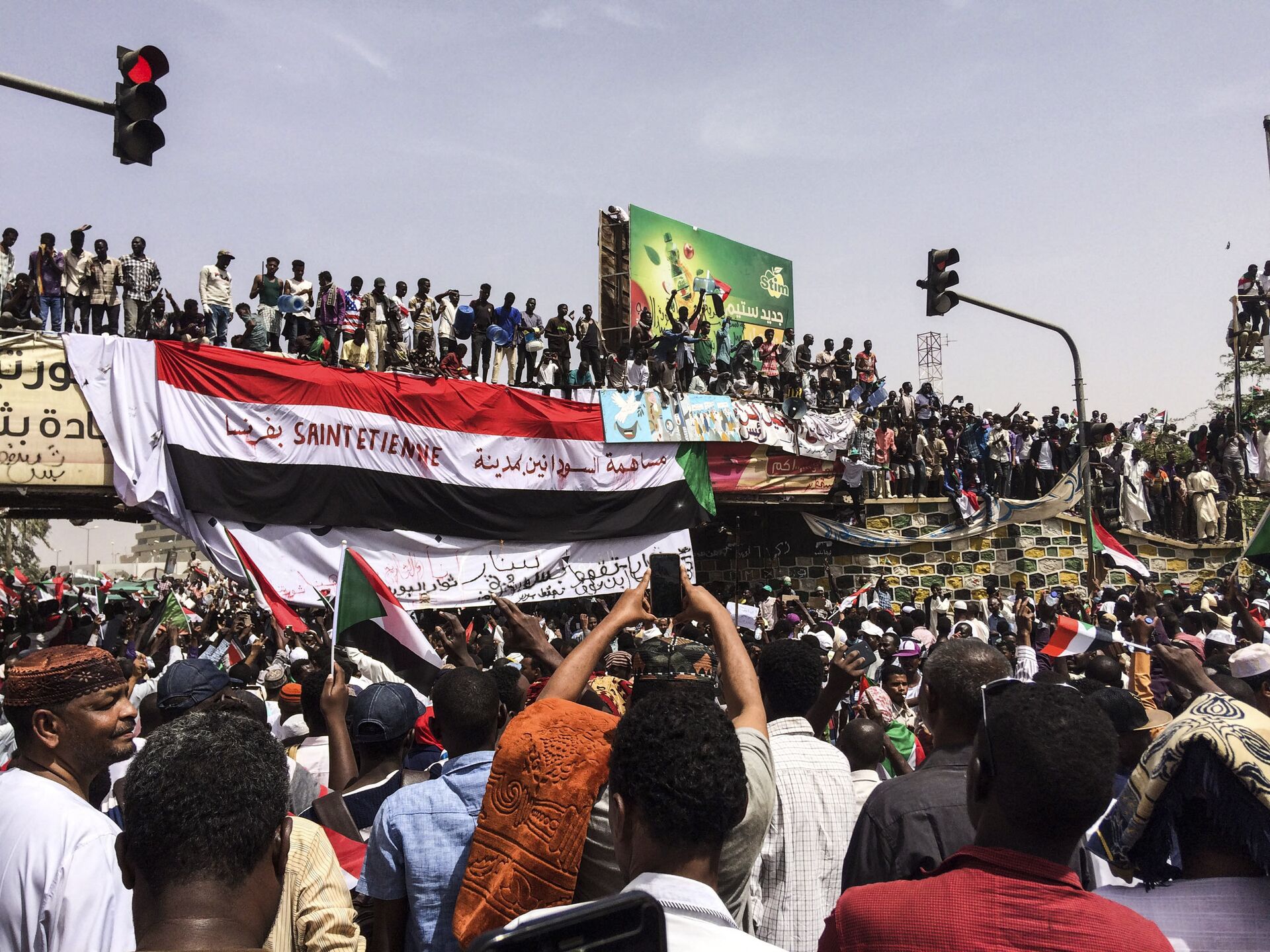 Demonstrators gather in Sudan's capital of Khartoum, Friday, April 12, 2019. The Sudanese protest movement has rejected the military's declaration that it has no ambitions to hold the reins of power for long after ousting the president of 30 years, Omar al-Bashir. The writing on the Sudanese flag says 'With the participation of the Sudanese in Saint Etienne, France.' - Sputnik International, 1920, 20.10.2021
