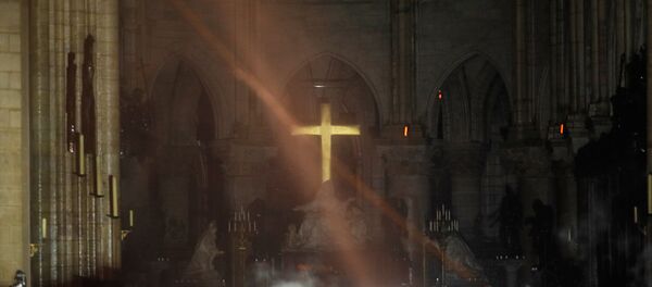 Smoke rises around the alter in front of the cross inside the Notre Dame Cathedral as a fire continues to burn in Paris, France, April 16, 2019. Smoke rises around the alter in front of the cross inside the Notre Dame Cathedral as a fire continues to burn in Paris, France, April 16, 2019. - Sputnik International