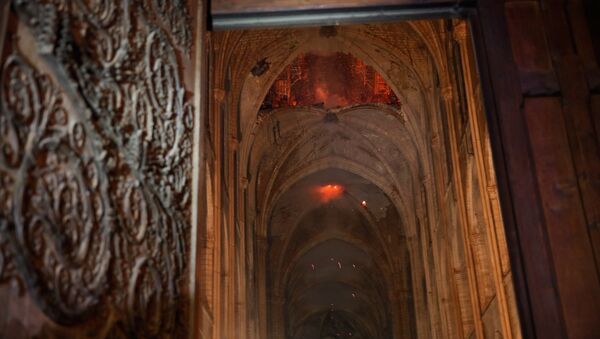 Flames and smoke are seen as the interior continues to burn inside the Notre Dame Cathedral in Paris, France, April 16, 2019. - Sputnik International