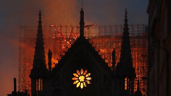 Flames and smoke rise from Notre Dame cathedral as it burns in Paris, Monday, April 15, 2019 - Sputnik International