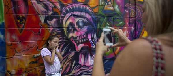 A girl poses for a picture in front of a mural depicting the statue of liberty as death, at Bolivar square in Caracas, Venezuela. File photo A girl poses for a picture in front of a mural depicting the statue of liberty as death, at Bolivar square in Caracas, Venezuela. File photo - Sputnik International