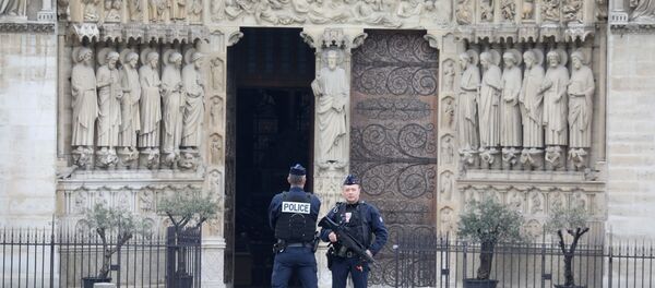 French police officers stand outside Notre-Dame-de Paris on 16 April, 2019 in Paris in the aftermath of a fire that devastated the cathedral French police officers stand outside Notre-Dame-de Paris on 16 April, 2019 in Paris in the aftermath of a fire that devastated the cathedral - Sputnik International